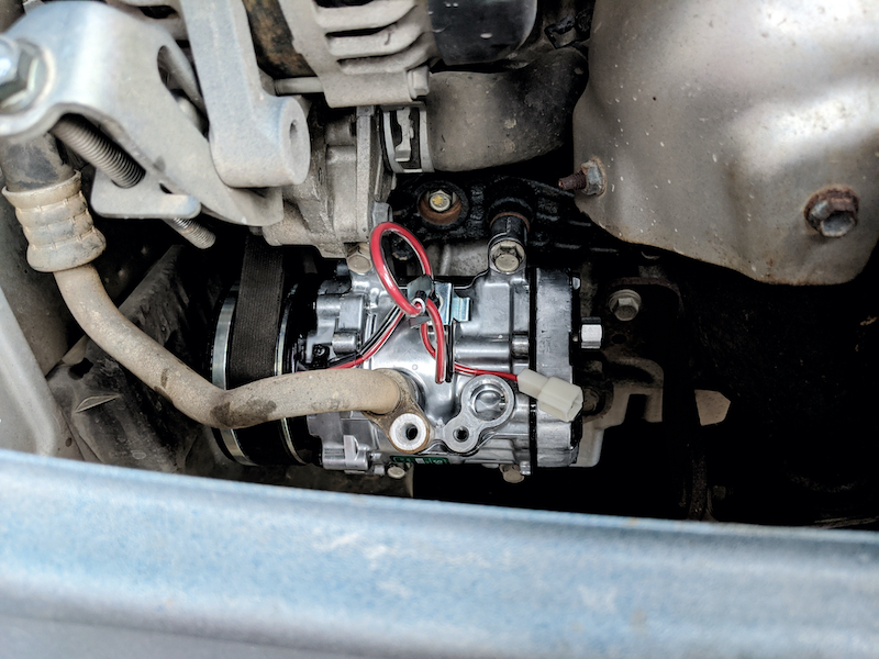 New AC compressor after installation in a car
