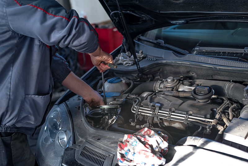 Mechanic replacing an engine in a mini van