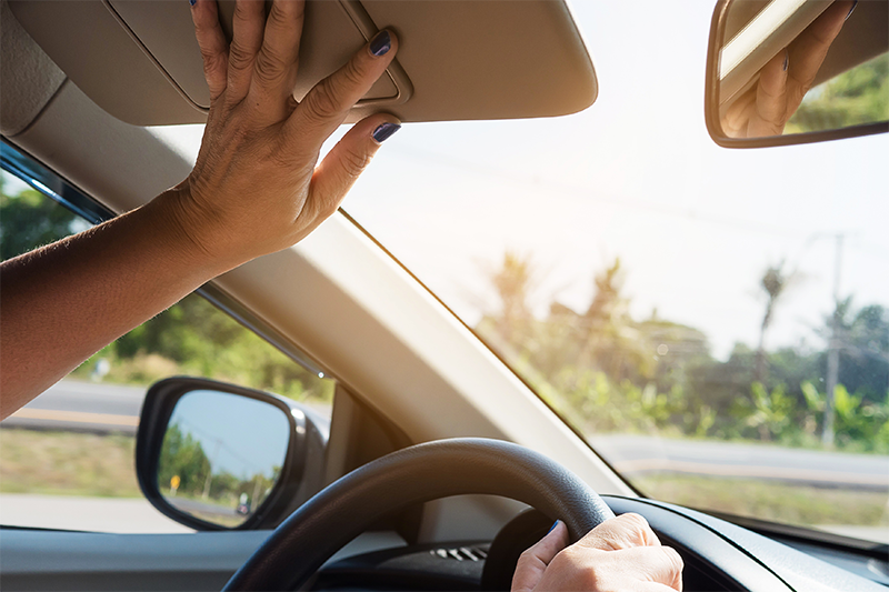 Woman adjusting the sun visor in her car